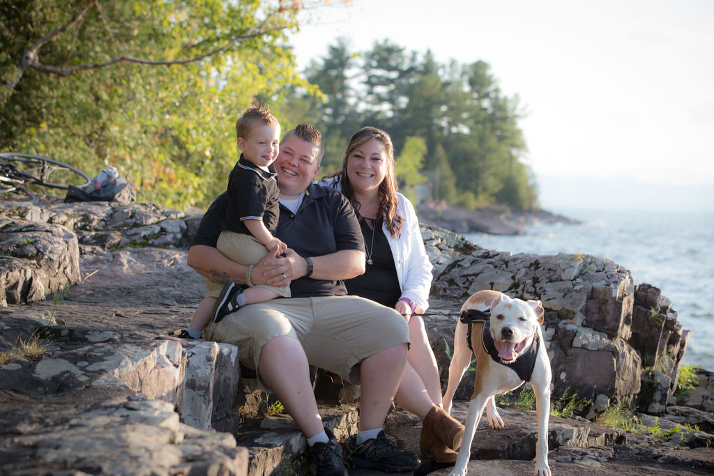 A family sitting outside next to a dog.