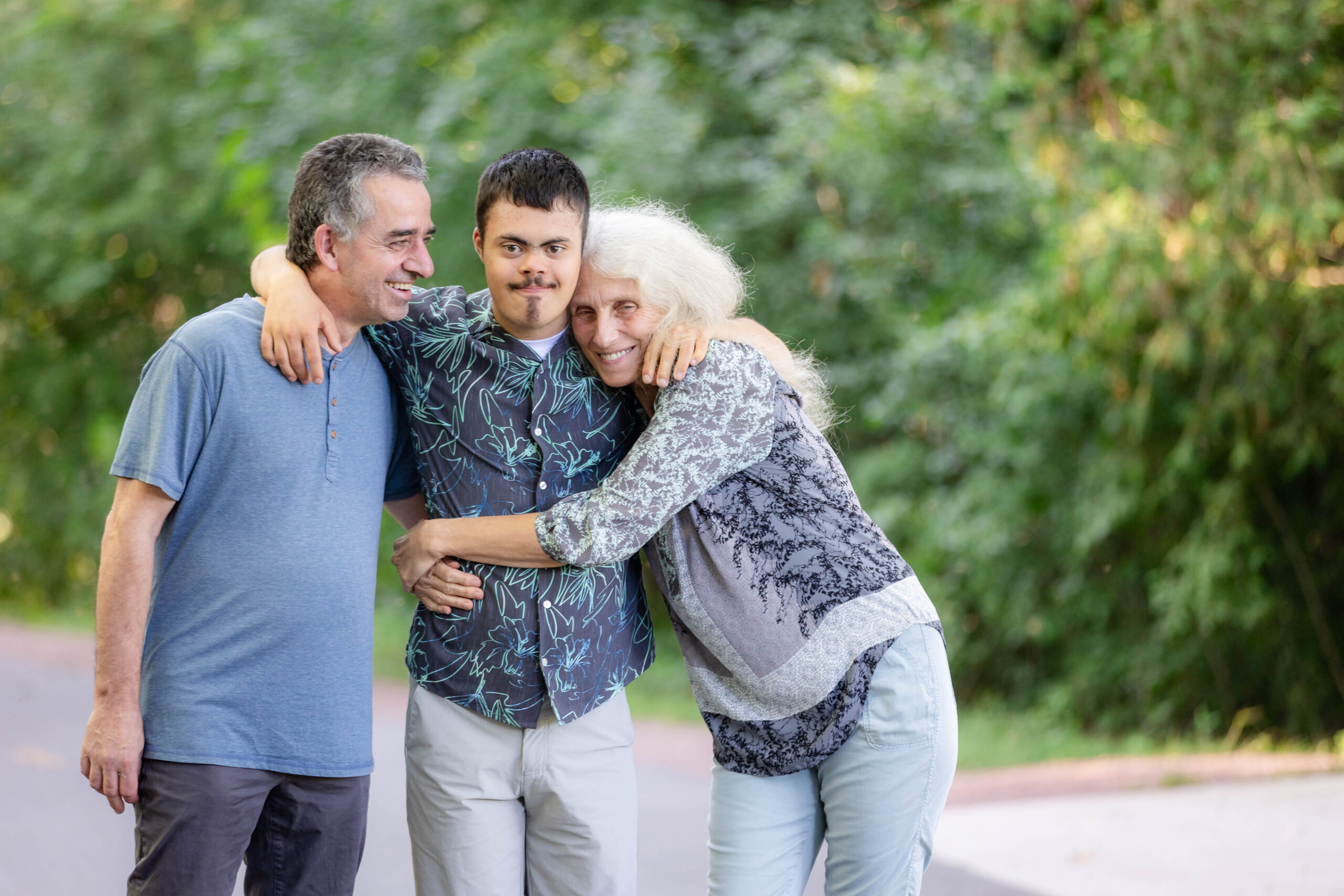 Two parents hugging their son.